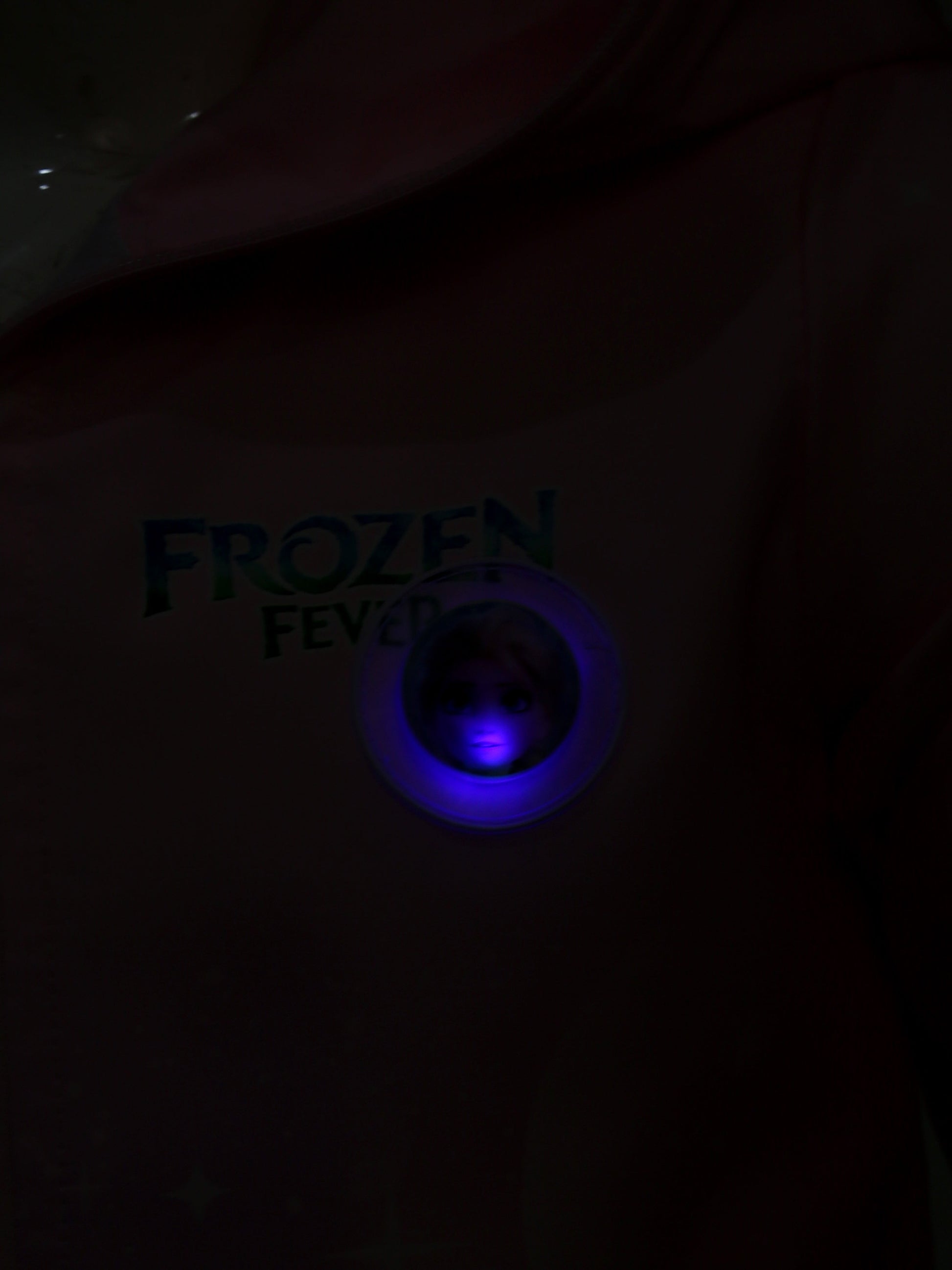 Dark shirt with 'Frozen Fever' text and blue light in the center