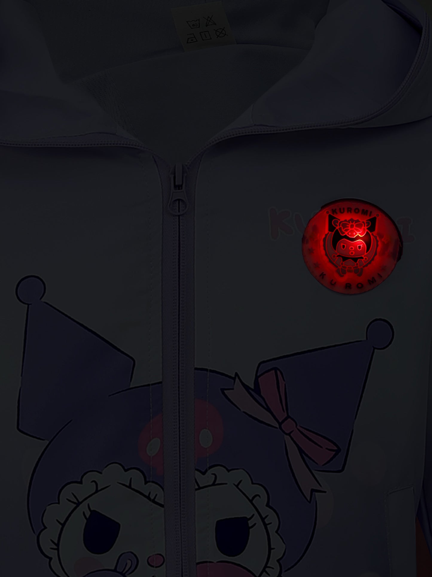 Dark hoodie with cartoon character and glowing red emblem on chest